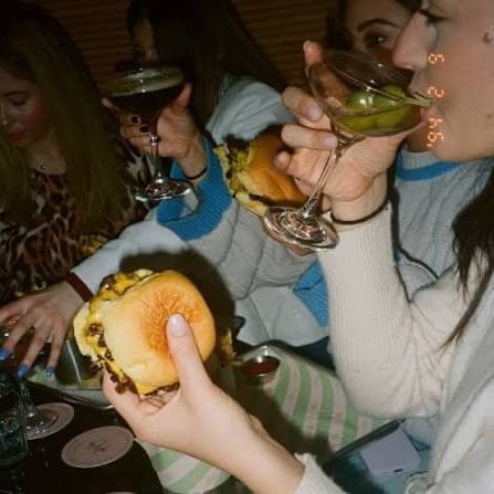 Friends around a table with burgers and drinks