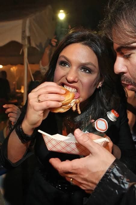 Two people sharing burgers at an outdoor evening festival