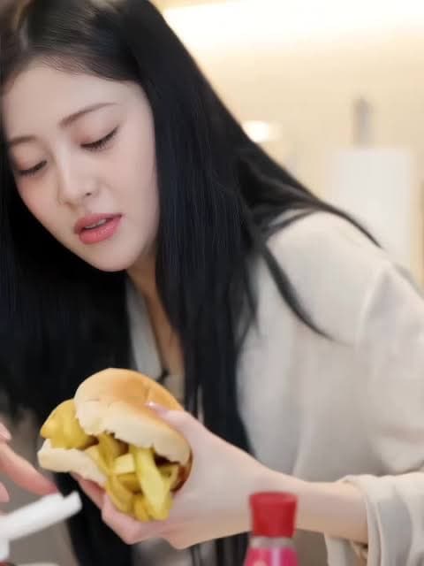 A woman about to bite into a burger