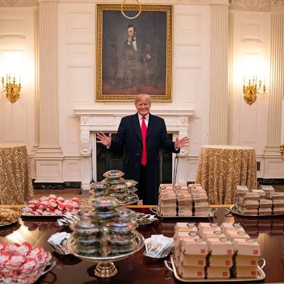 A formal dining table covered in fast-food burgers